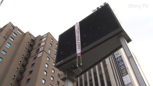 지난 12일부터, 서울 프레스센터 앞 전광판 위에서 목숨을 건 고공농성을 벌이고 있는 C &M 비정규직 노동자(사진출처-오마이TV 영상 캡쳐)